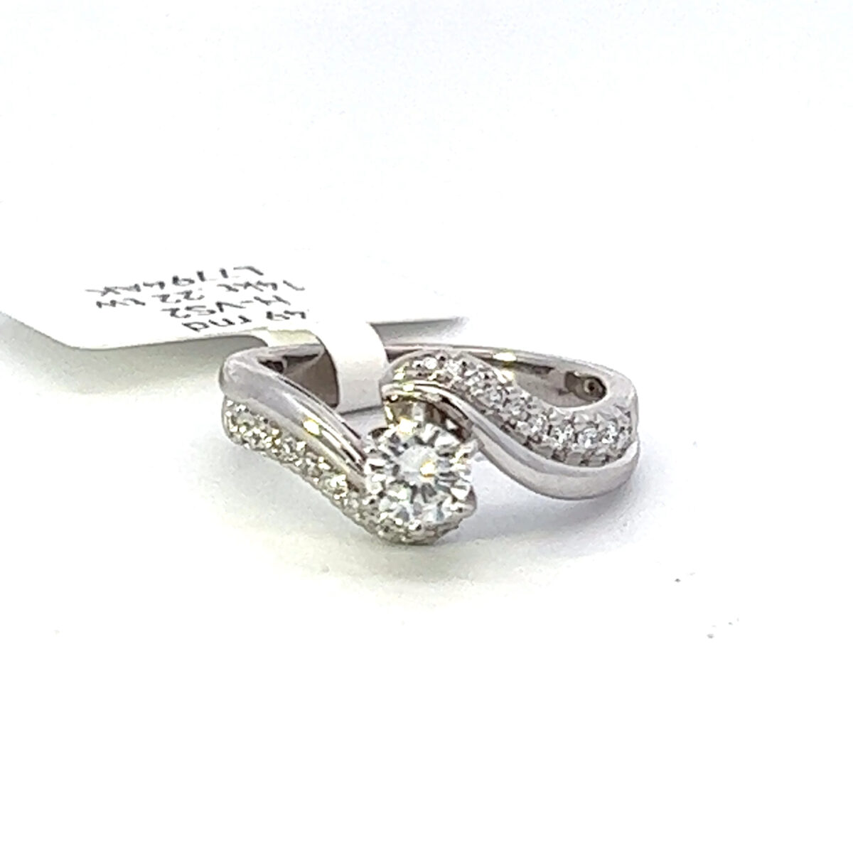 .49 carat Round cut natural mined diamond that is an H in color and VS2 clarity. Set in 14 kt white gold Swirl style setting with full cut round natural diamonds with an additional total weight of .22 carats total weight. Total of all diamonds equals .71 carats.