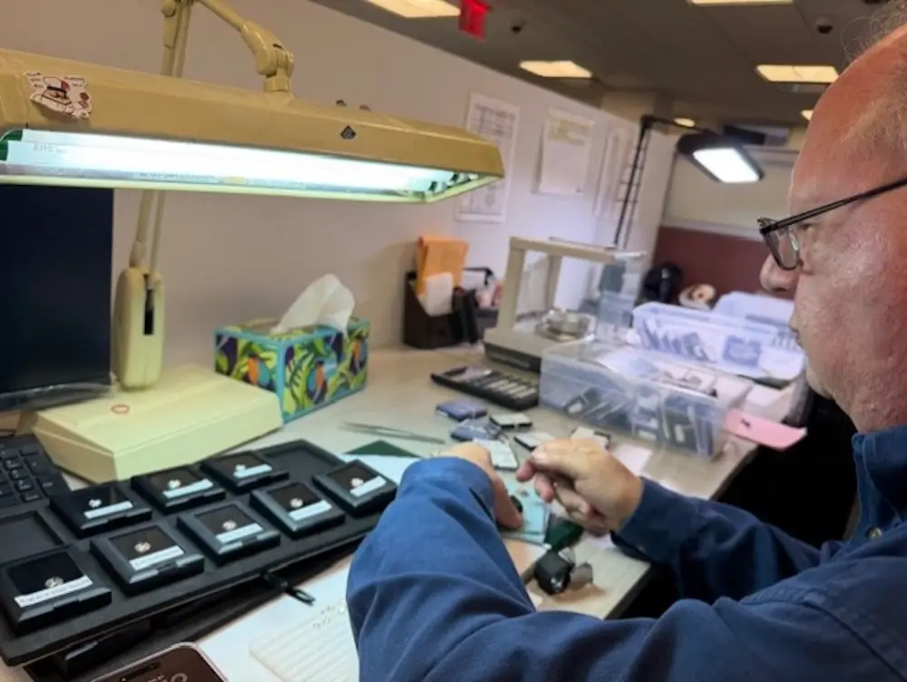 Elliott Herzlich of Elliott's Jewelers inspecting diamonds at a work station