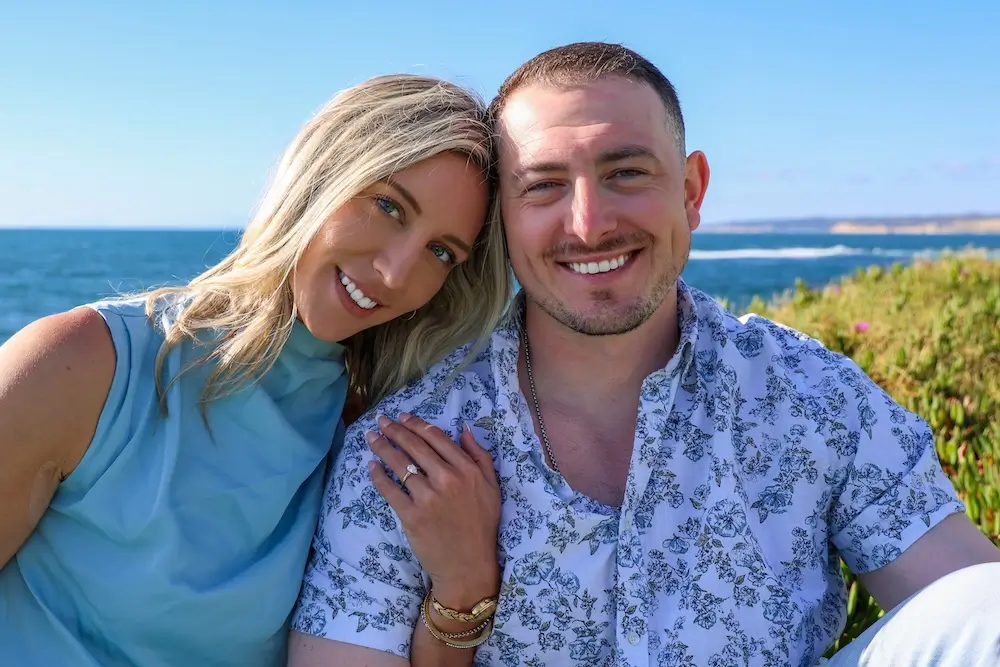 Devin & Casey smiling on the beach in San Diego, newly engaged
