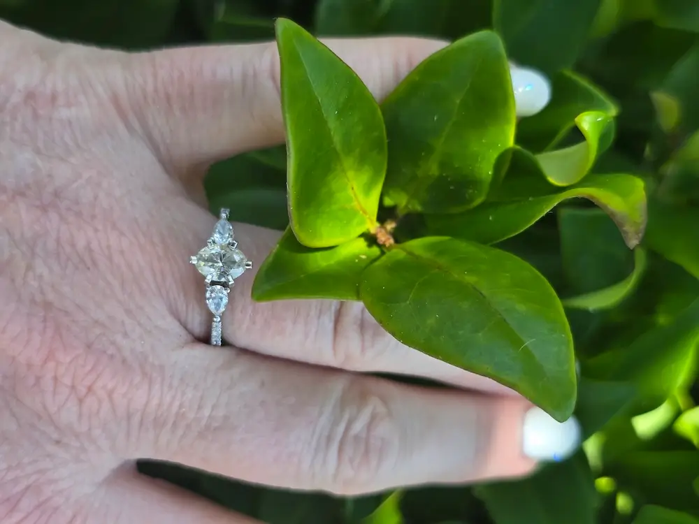 diamond wedding ring on finger next to plant