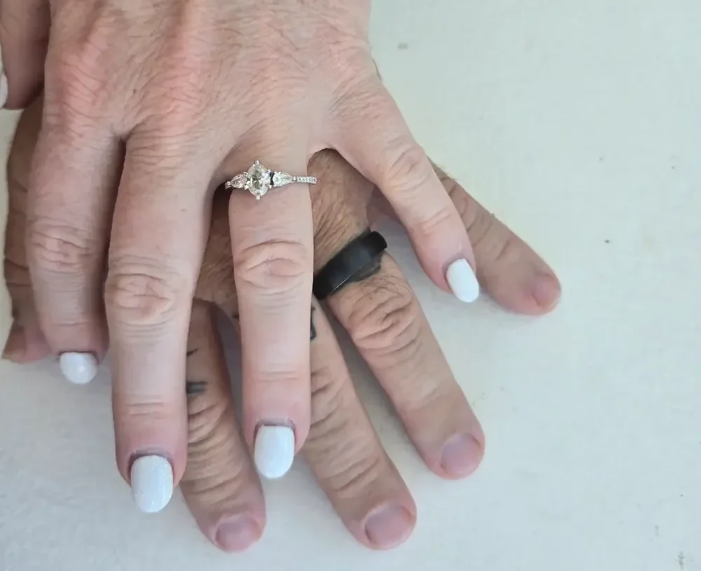Jenni & Jay holding hands, diamond wedding ring on Jenni's finger